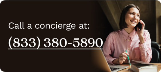 Woman in a pink blouse sitting at her desk, talking on the phone