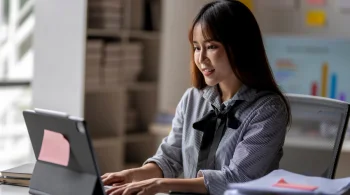 A woman working on her laptop at a desk.
