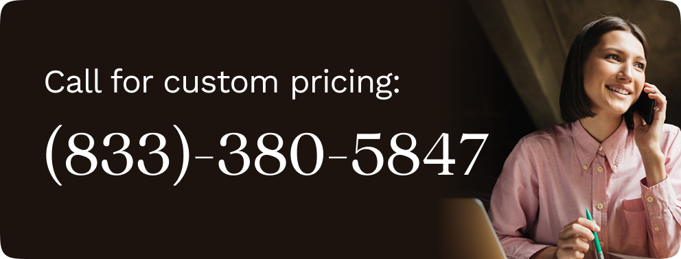 Woman in a pink blouse sitting at her desk, talking on the phone