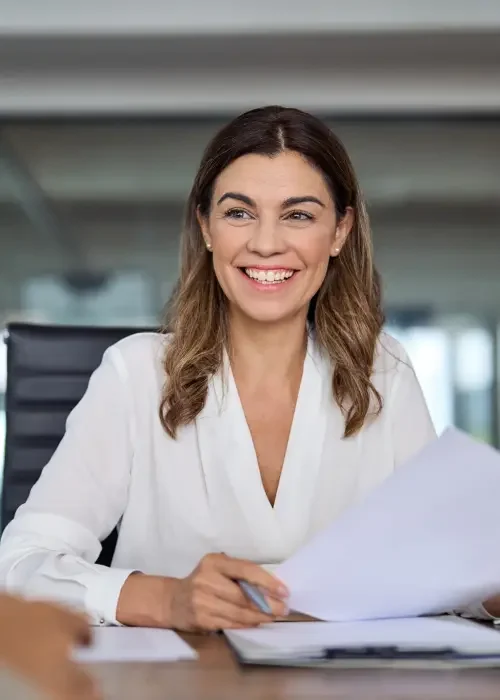 A contract lawyer sitting at a table reviewing financial and commercial contracts for a business