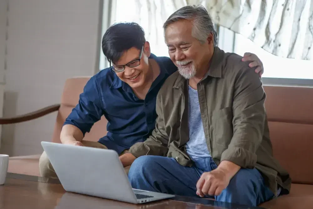 A son helps his father set up a healthcare proxy, also known as a health care power of attorney, and other estate planning documents online.