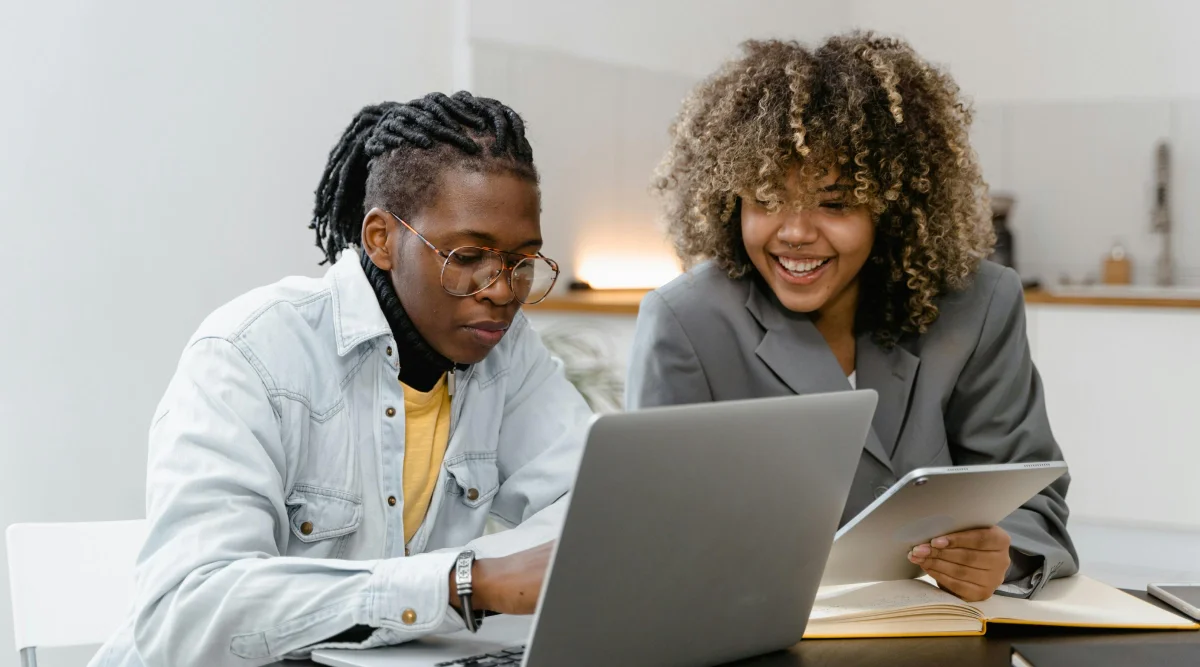 A man and woman looking at a laptop screen.
