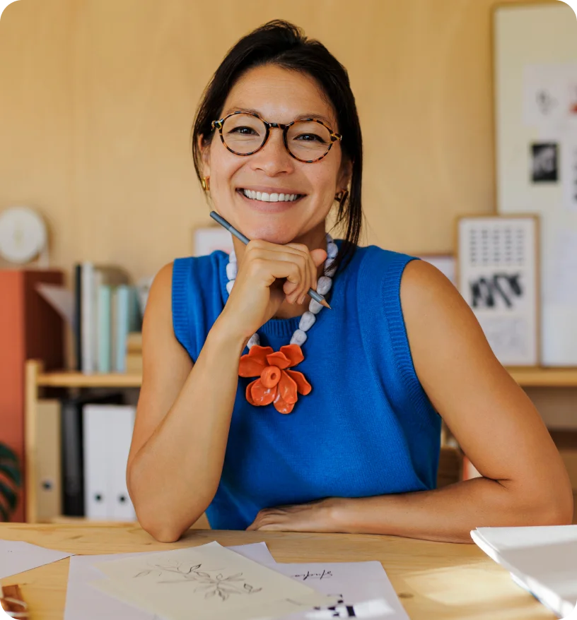 Smiling woman in blue shirt sitting at desk
