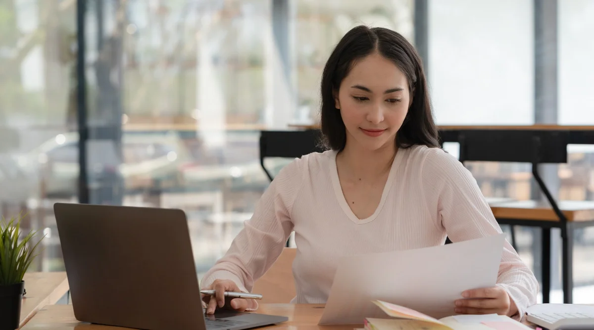 Woman reviewing documents in a bright office setting