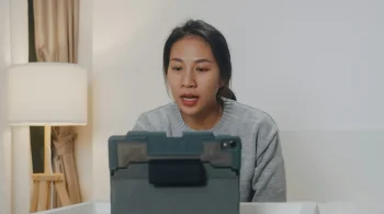 Woman speaking to tablet in a bright room