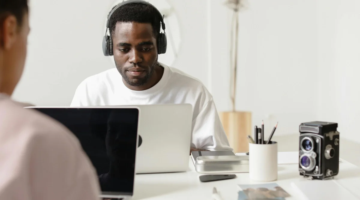 Person with headphones using a laptop at a desk