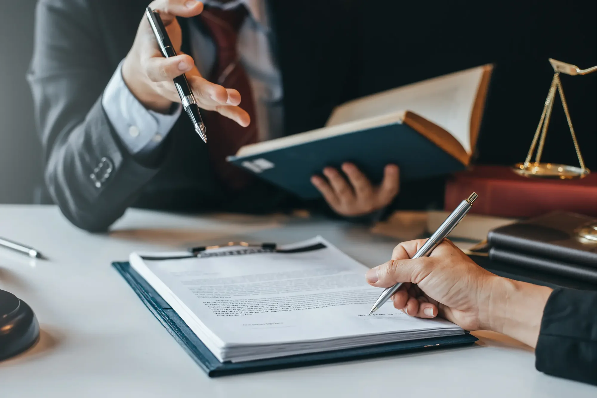 A man signs the grantor trust paperwork in the presence of an attorney.