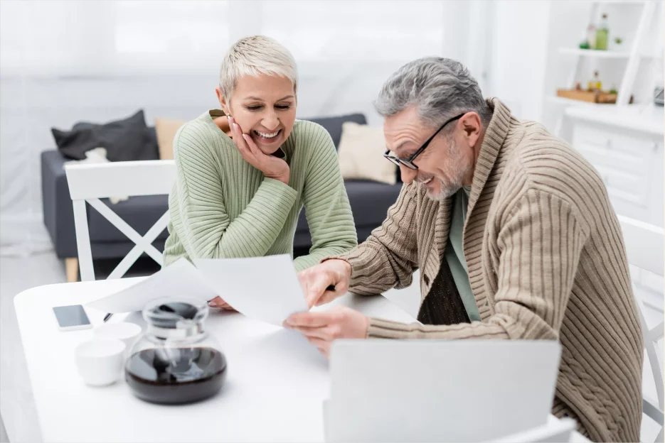 A woman and a man examine their trust document, ensuring the details of their assets and beneficiaries are correctly recorded.