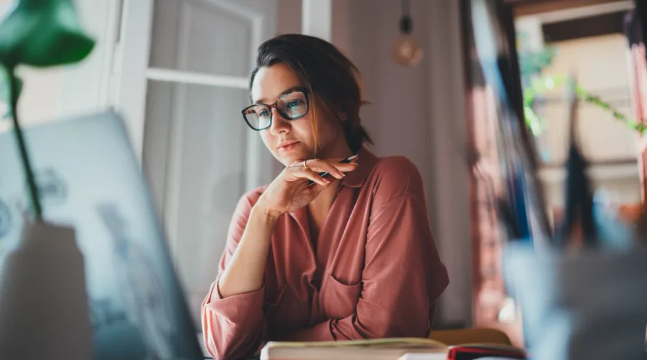 A woman looking at a laptop to understand what a holographic will is and the requirements of a holographic will.