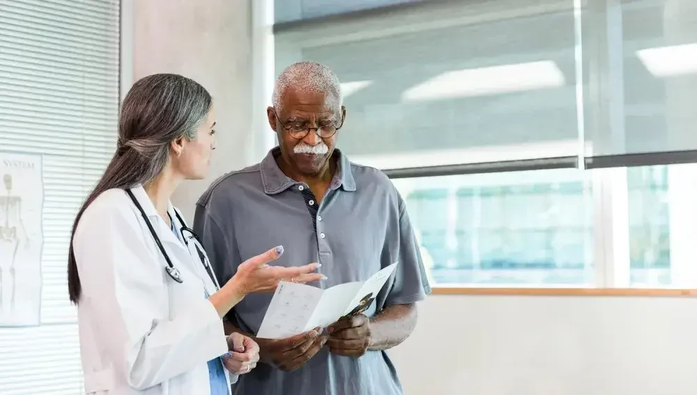 An image of a doctor and a patient discussing a living will vs. an advance directive for medical planning and which is best for them.