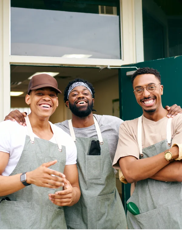 Jovial employees pose for a photo outside of restaurant