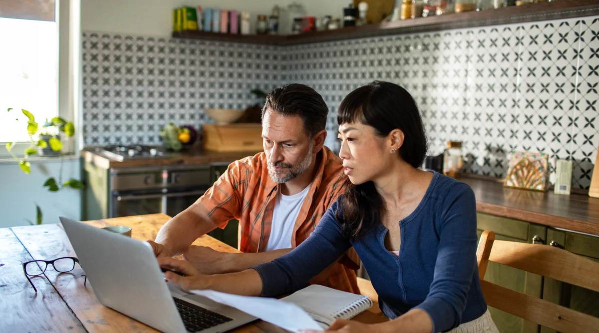 Couple working together on a laptop in a kitchen