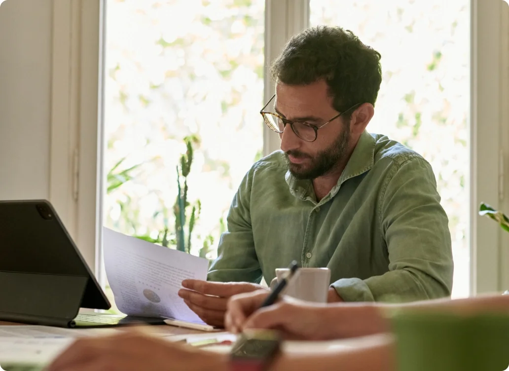 Man in green shirt looking at piece of paper