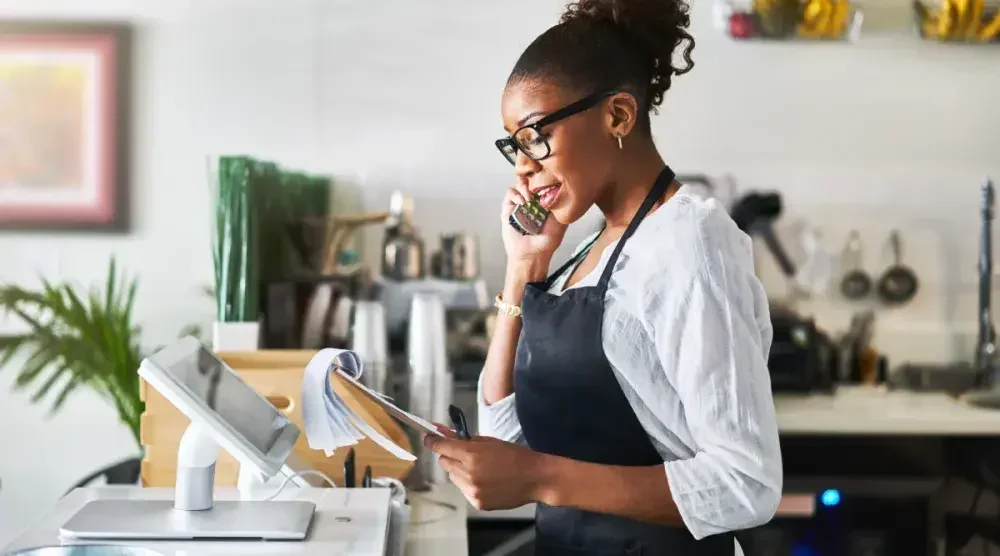 A Texas bakery owner stands in her store and reviews an order with a client.