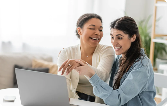 two young women working on their laptop