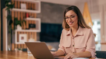 Woman happily working on a laptop at home