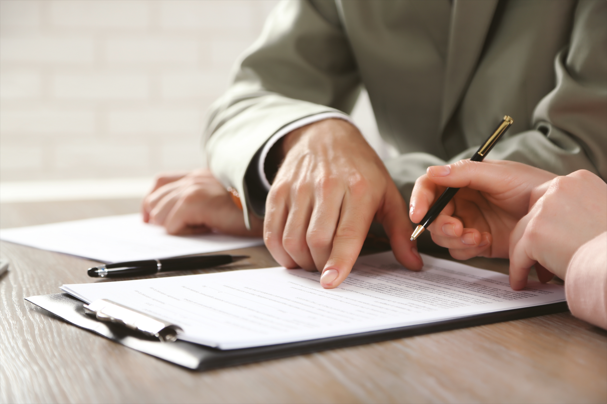 A picture showing a professional helping a woman to create her financial and asset management document, while clarifying how to add the per stirpes distribution clause in the document.