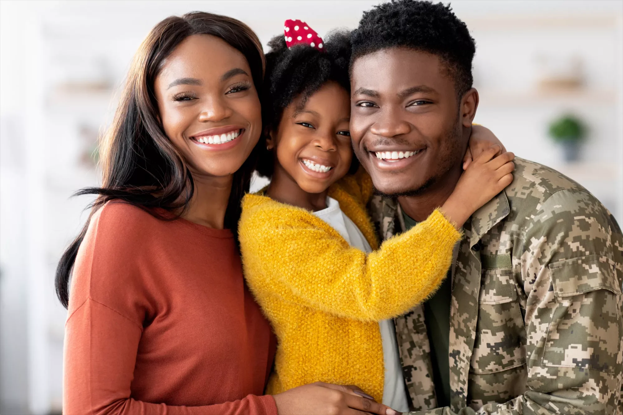 A husband and wife holding their daughter closely and smiling. When creating a will in Texas the couple should consider how they can protect their spouse and child after one dies.