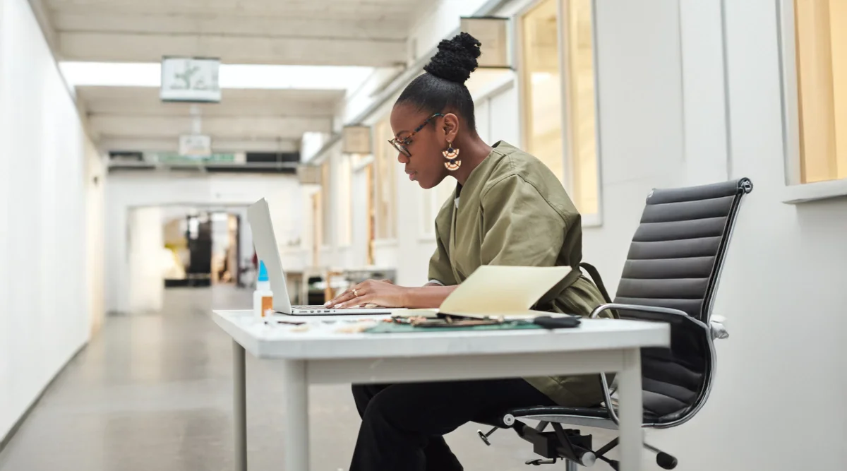 Woman working at a laptop in a modern, open space