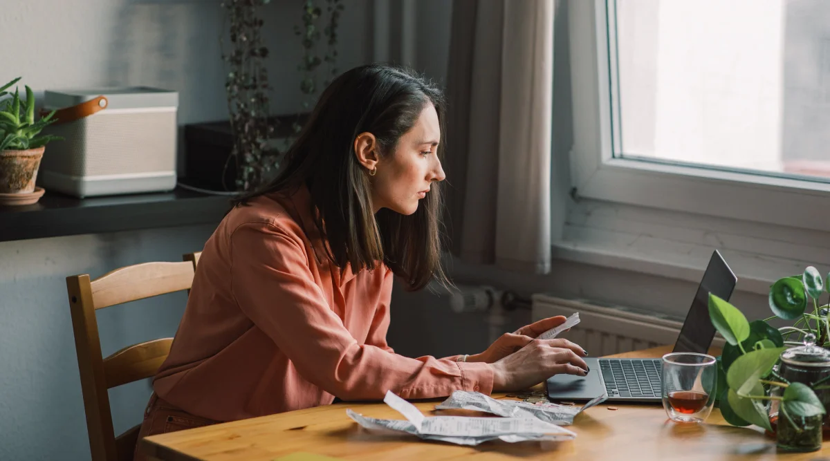 Woman focused on laptop at a wooden table