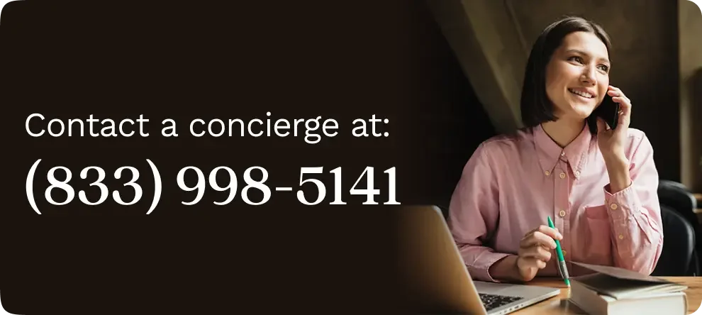 Woman in a pink blouse sitting at her desk, talking on the phone