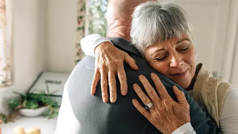 A husband and wife embrace in relief after filing their living trust in California.