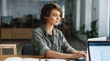 Woman typing on a laptop.