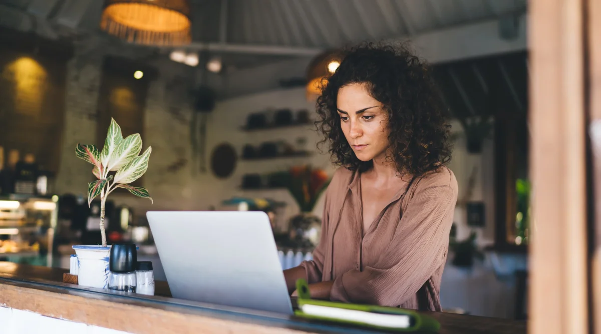 A woman working on her laptop in a cafe.