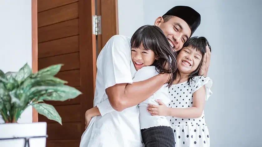 A man hugs his two children in the doorway of their home. Heirs typically don't have to worry about having to pay estate tax unless there's a sizable amount of assets at stake.