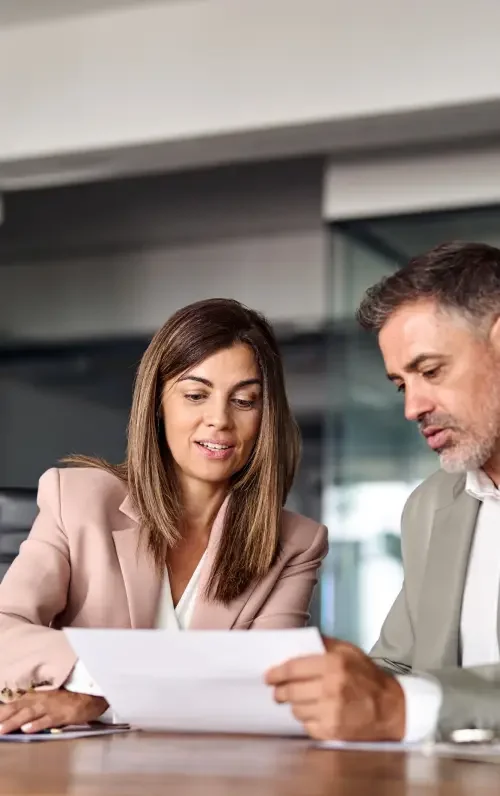 A commercial real estate attorney sitting at a table and walking through a commercial lease agreement with her client