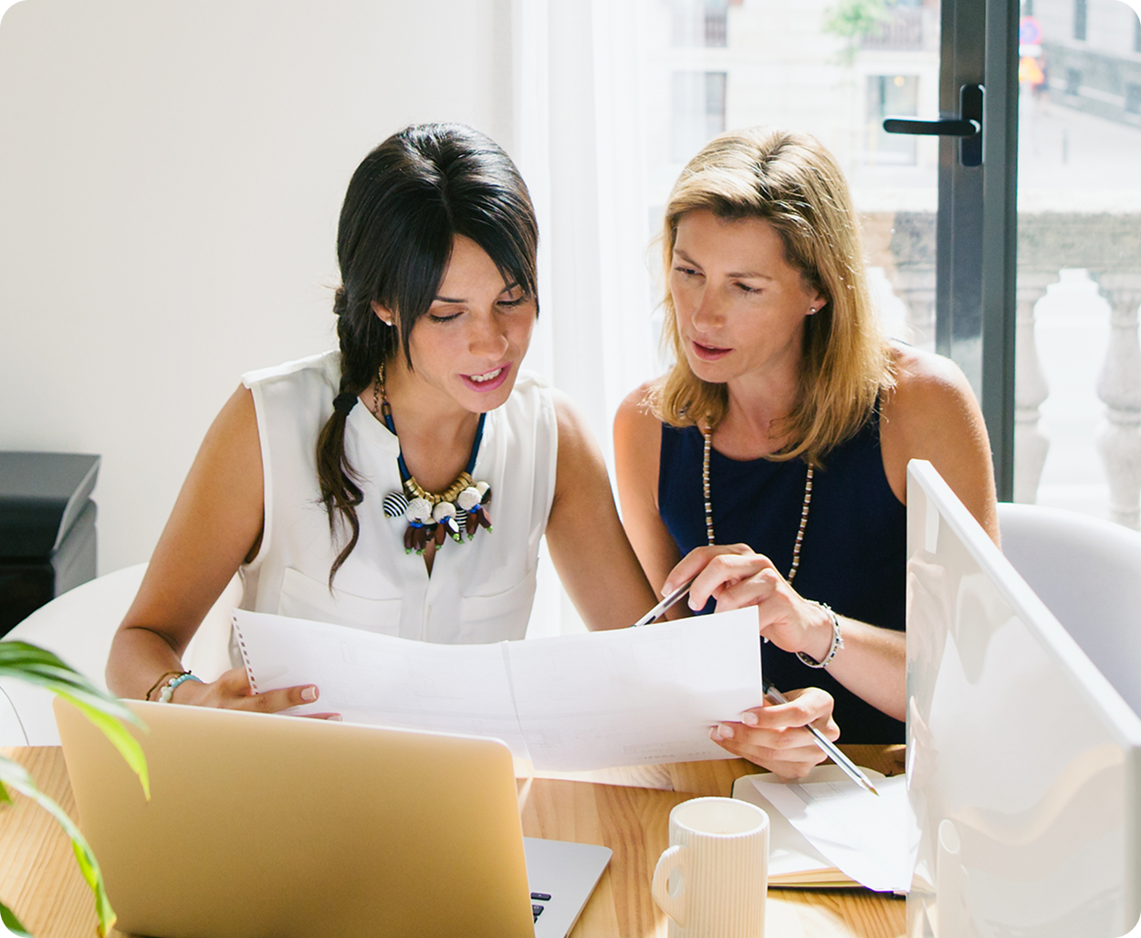 Two women discuss a project in a modern office
