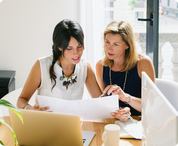 Two women discuss a project in a modern office