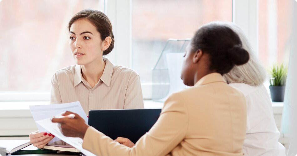 3 women sitting in a conference room looking at dissolution paperwork created with LegalZoom.