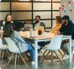 group of coworkers in a meeting at a large table 