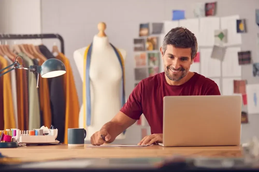 A tailor sits in his studio and fills out his trademark application.