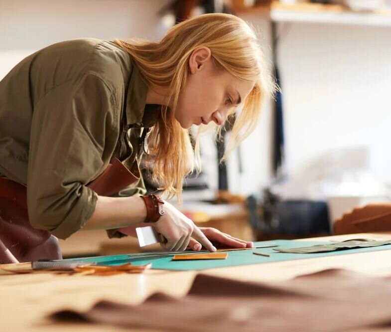 Woman standing at drafting table working on a technical design