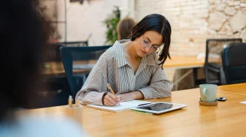 Woman taking notes with a tablet in a shared workspace