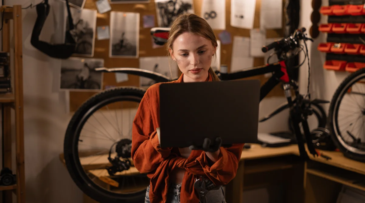 Woman reviews items on her computer in bike shop 