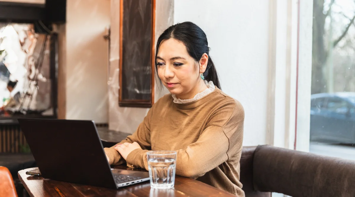 Woman working on a laptop in a cozy cafe