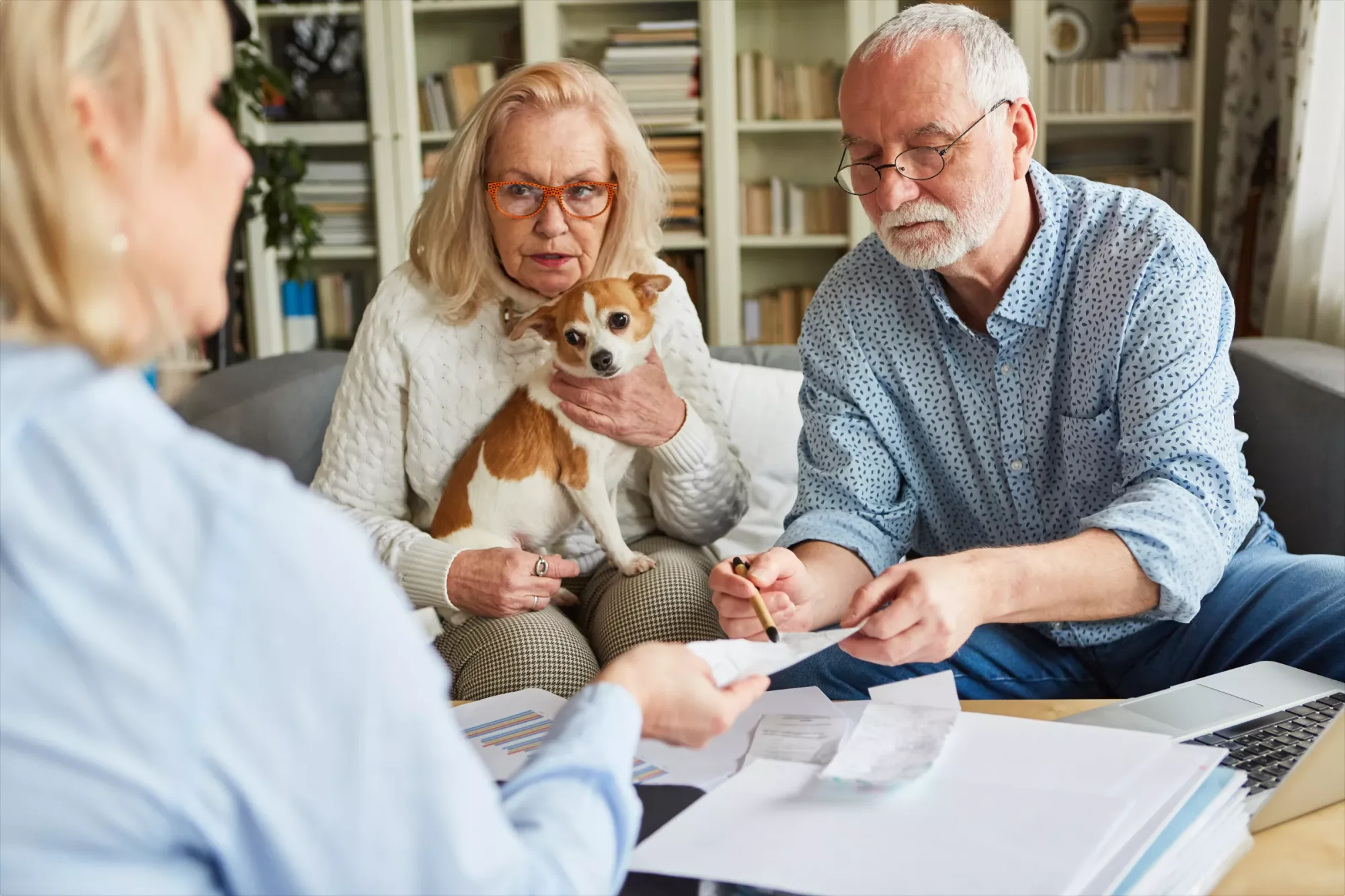 An elderly couple with their pet dog is verifying their last will and clarifying their doubts with their estate planning attorney.