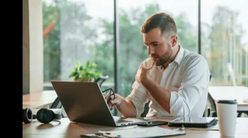 Man focused on laptop work in a serene, green office