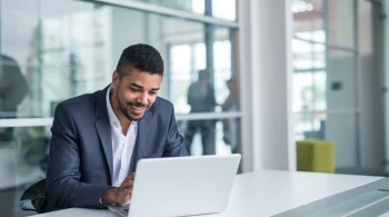 Businessman smiling while working on a laptop