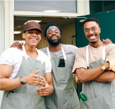 Jovial employees pose for a photo outside of restaurant