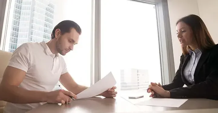 An attorney and her client are reviewing a general power of attorney document in a meeting room.