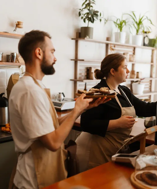 A woman and man work in an aesthetic coffee shop
