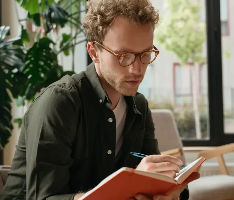 A man writing in his notebook