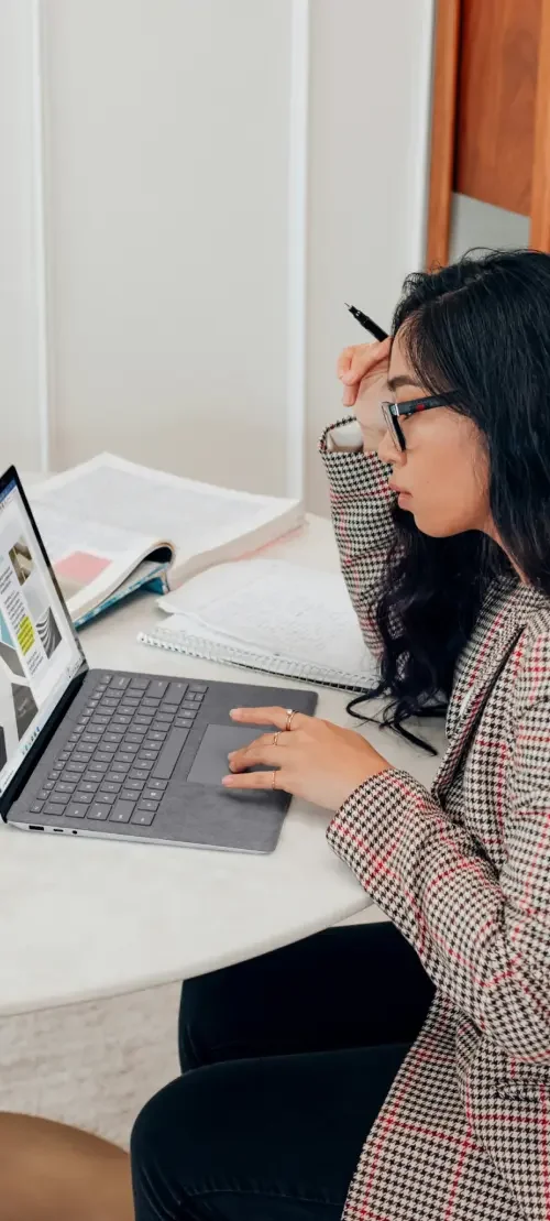 A business owner sitting at a table researching on a laptop what a lawyer would include in a consulting agreement