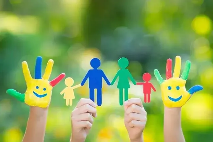 Children with painted hand smileys and a family figure cutout illustrating the top 5 benefits of a living trust for estate planning and family protection.