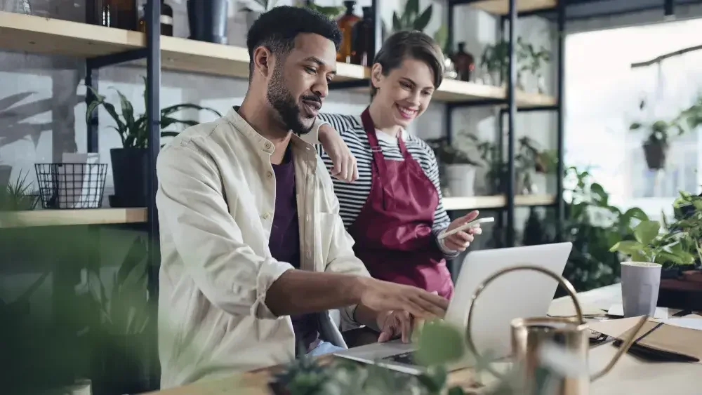 coworkers looking at a laptop in a flower shop