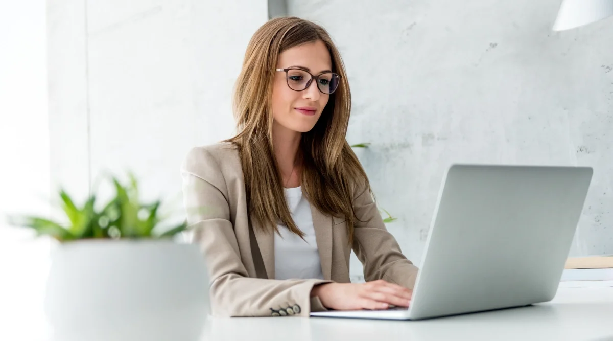 Woman typing on a laptop in a bright, minimalist office